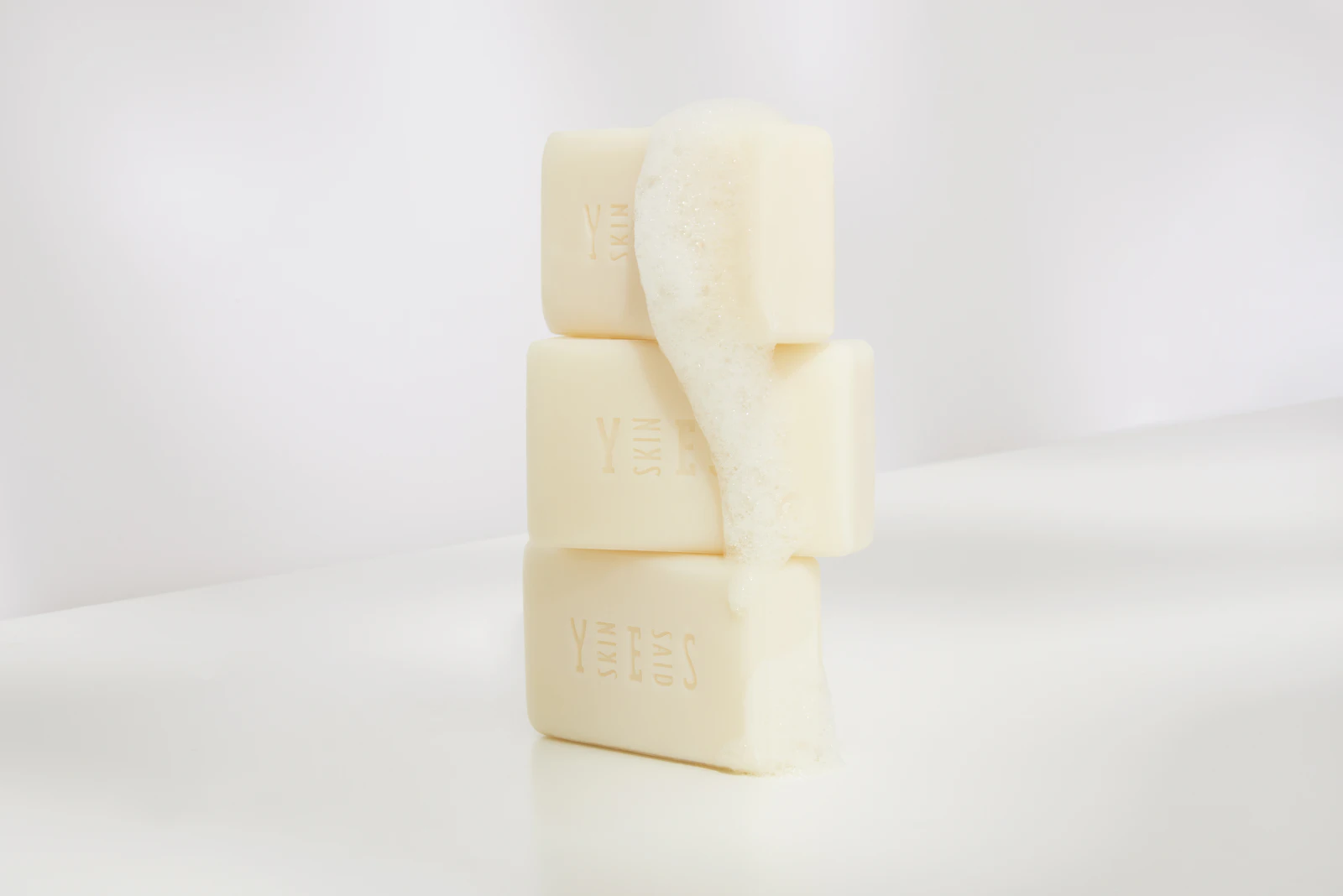 Three stacked Skin Said Yes soap bars with lather