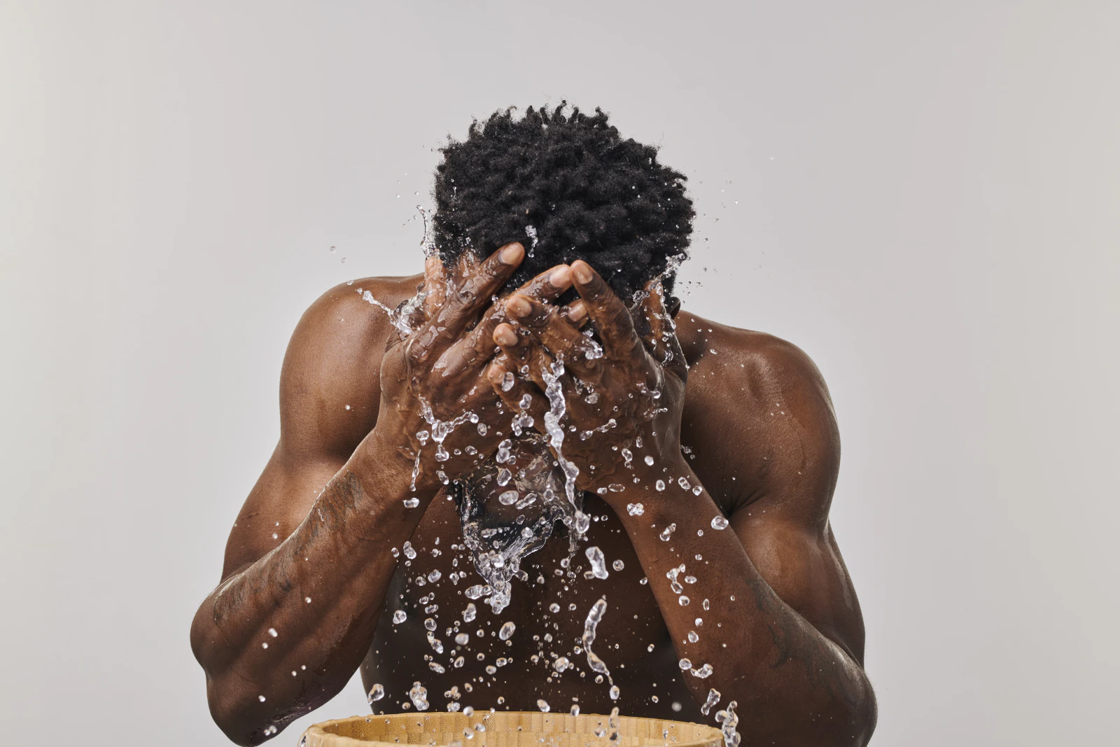 Man splashing water on his face while washing